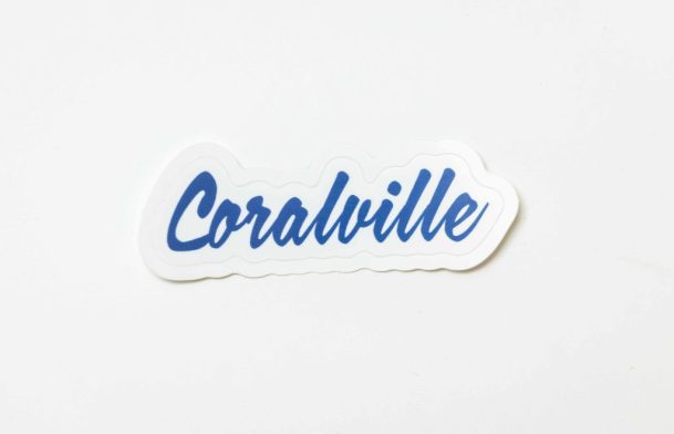 A product photo of the script Coralville word mark logo with blue text, printed by Sticker Giant is seen photographed for Shop Think Iowa City, Tuesday, Sept. 24, 2024, in Coralville, Iowa. MANDATORY CREDIT: Joseph Cress/Think Iowa City